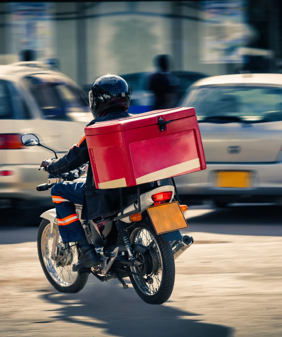 Repartidor en moto con caja de delivery rodando por la ciudad